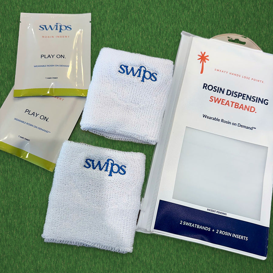 What comes in one Swips 2-Pack, laid out on green turf: the retail pouch, two white terry cloth sweatbands and two foil rosin insert sachets
