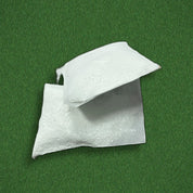 Two Swips rosin inserts out of their sachets on turf, showing the porous packets that drop into the band