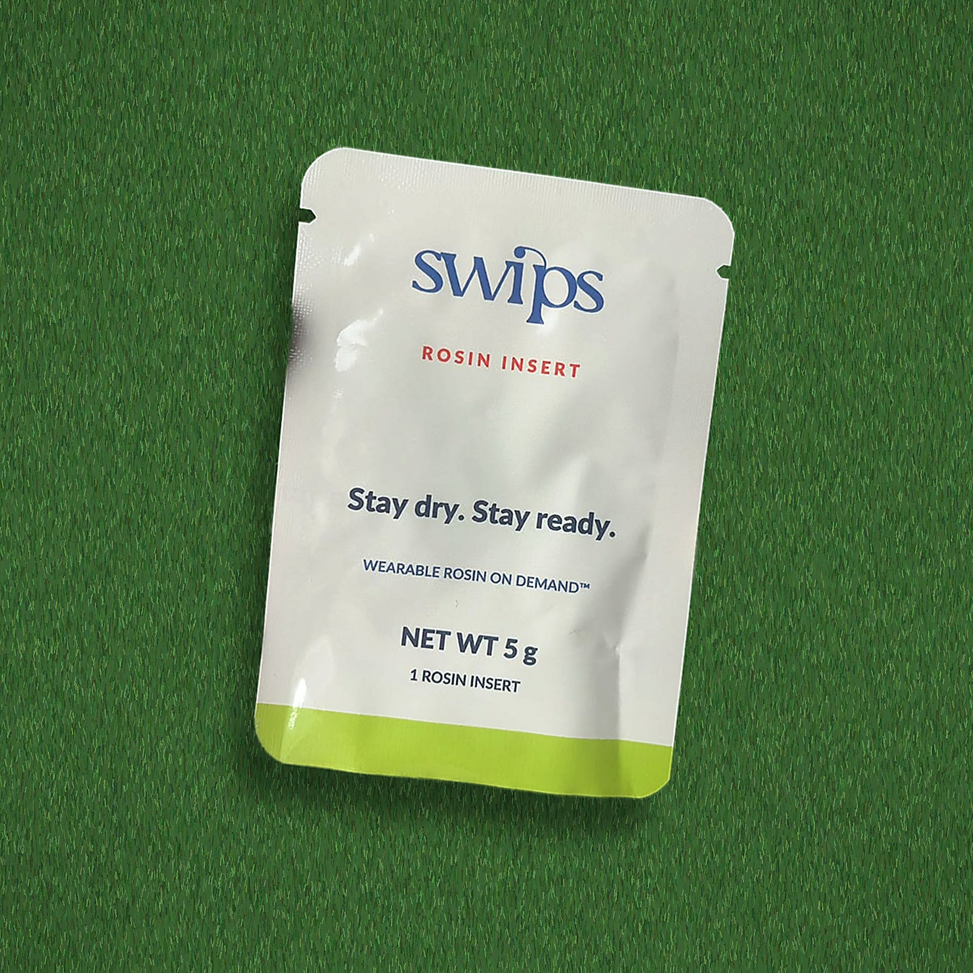 A single sealed Swips rosin insert sachet on turf, Stay dry. Stay ready., net weight 5 g