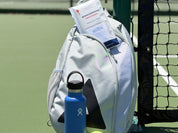 A Swips rosin insert sachet tucked into a pickleball bag beside the net, with a water bottle and a ball