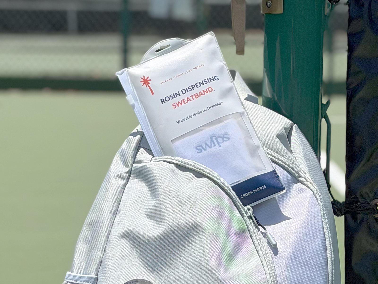 A Swips 2-pack package tucked into a pickleball bag pocket, courtside