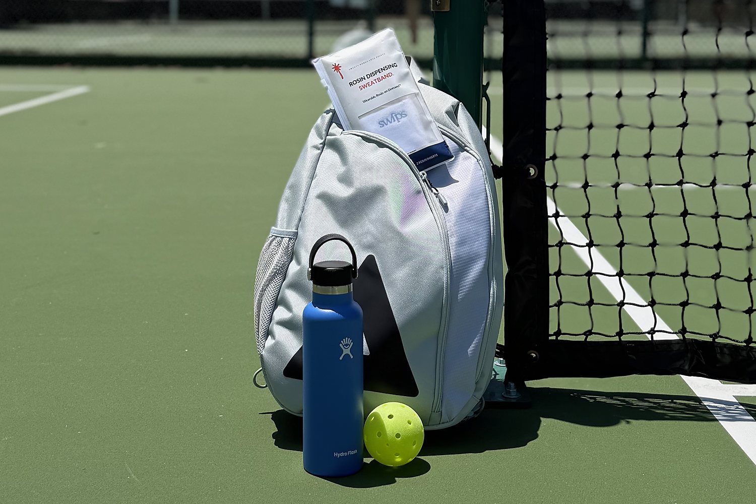 A Swips rosin insert sachet in a pickleball bag at the net, ready for the next game